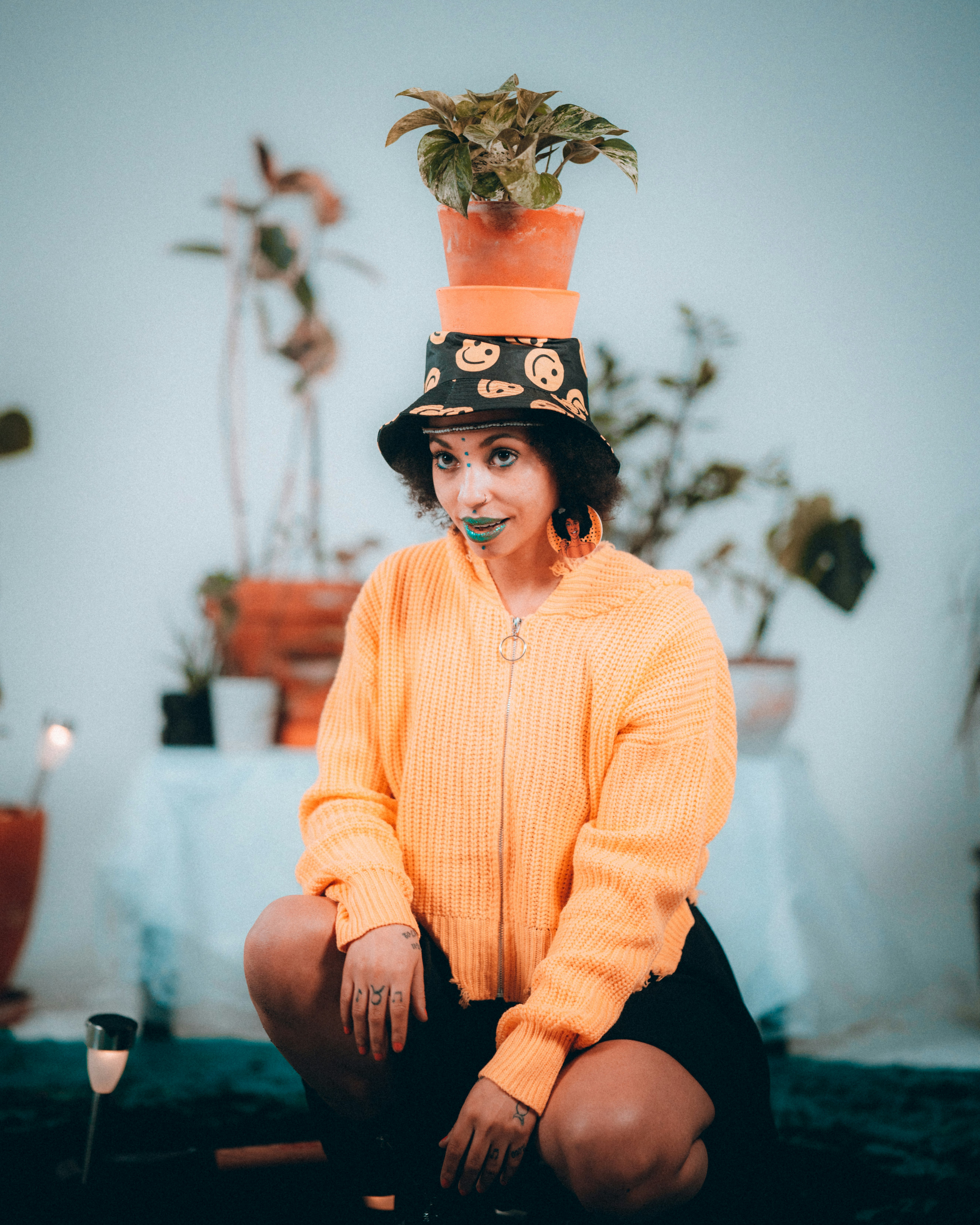 woman in yellow sweater and black pants wearing black hat sitting on brown wooden seat